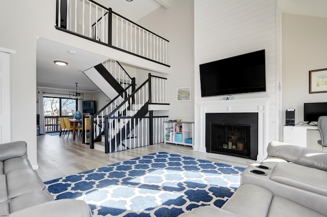 living room featuring beamed ceiling, hardwood / wood-style floors, and a high ceiling