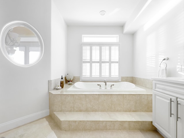 bathroom featuring a relaxing tiled tub, tile patterned floors, and vanity