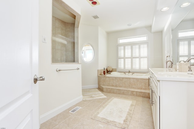 bathroom with vanity, a relaxing tiled tub, and tile patterned floors