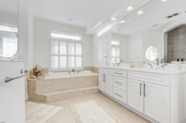 bathroom featuring tile patterned flooring, vanity, plenty of natural light, and a relaxing tiled tub