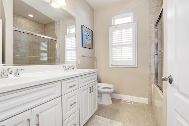 full bathroom with vanity, bath / shower combo with glass door, tile patterned floors, and toilet