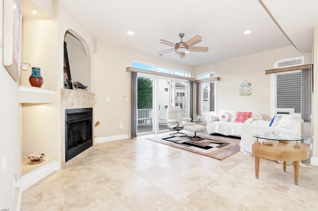 living room featuring ceiling fan and a fireplace