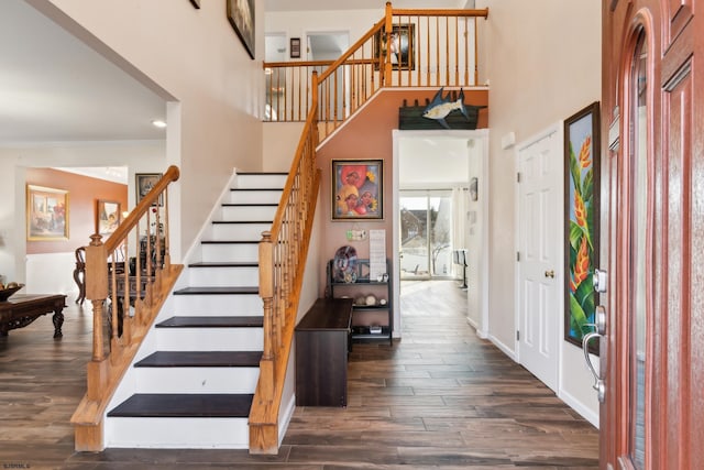 foyer entrance with a towering ceiling and dark hardwood / wood-style floors