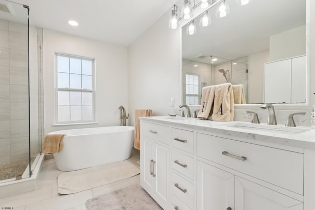 bathroom with vanity, independent shower and bath, and a healthy amount of sunlight