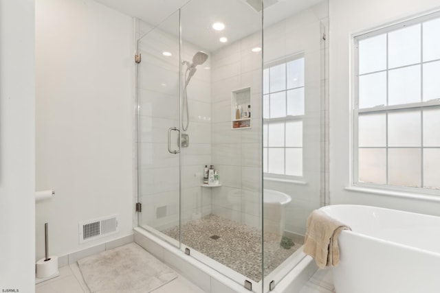 bathroom featuring tile patterned flooring and separate shower and tub