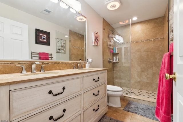 bathroom with vanity, toilet, a shower with door, and tile patterned flooring