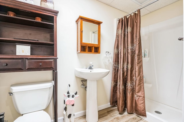 bathroom with a drop ceiling, sink, a shower with curtain, and toilet