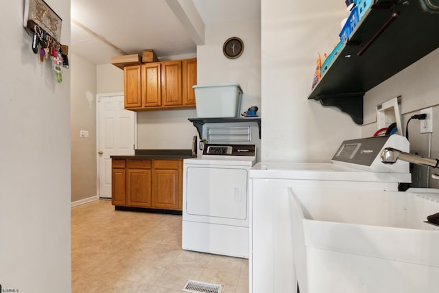 washroom with cabinets and independent washer and dryer