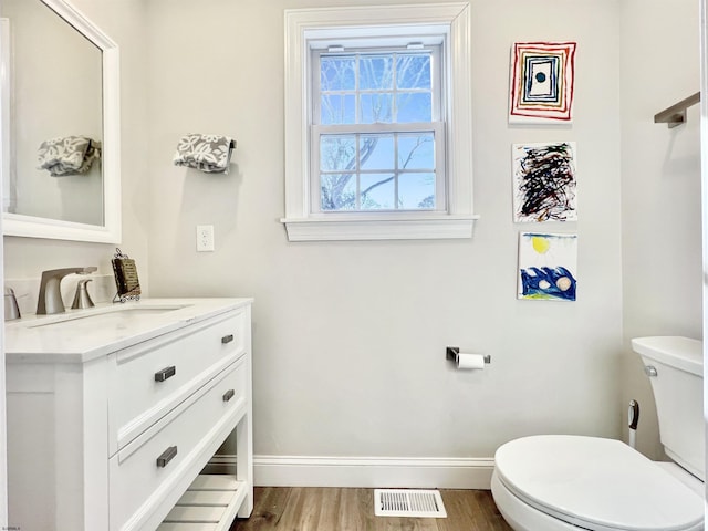 bathroom featuring vanity, hardwood / wood-style floors, and toilet