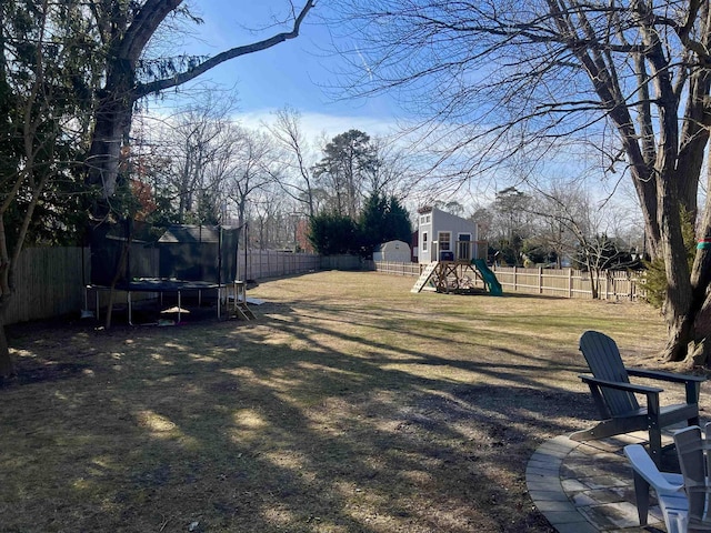 view of yard with a playground and a trampoline