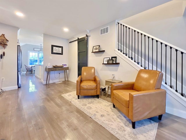 sitting room featuring a barn door and hardwood / wood-style floors