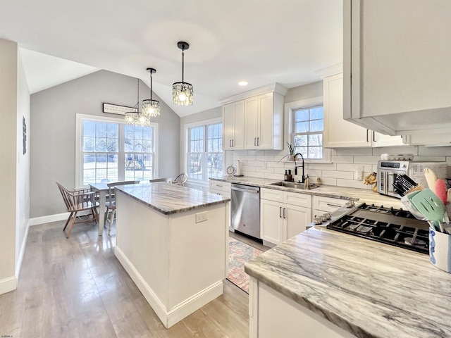 kitchen featuring sink, stainless steel dishwasher, white cabinets, and a kitchen island