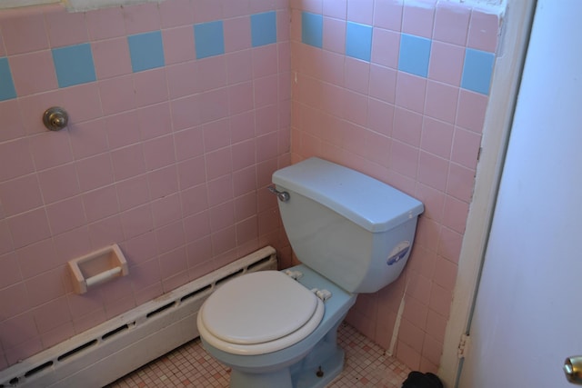 bathroom with tile patterned floors, toilet, tile walls, and a baseboard heating unit