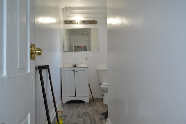 bathroom with vanity, wood-type flooring, and toilet