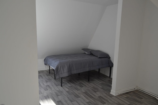 bedroom with wood-type flooring and vaulted ceiling