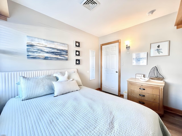 bedroom with dark hardwood / wood-style flooring