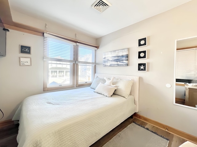 bedroom with dark hardwood / wood-style floors