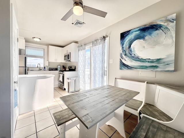 tiled dining area featuring sink and ceiling fan