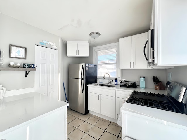 kitchen featuring light tile patterned flooring, stainless steel appliances, sink, and white cabinets