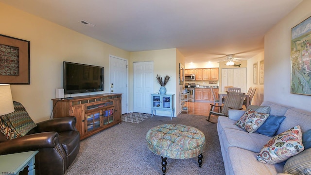 carpeted living room featuring ceiling fan