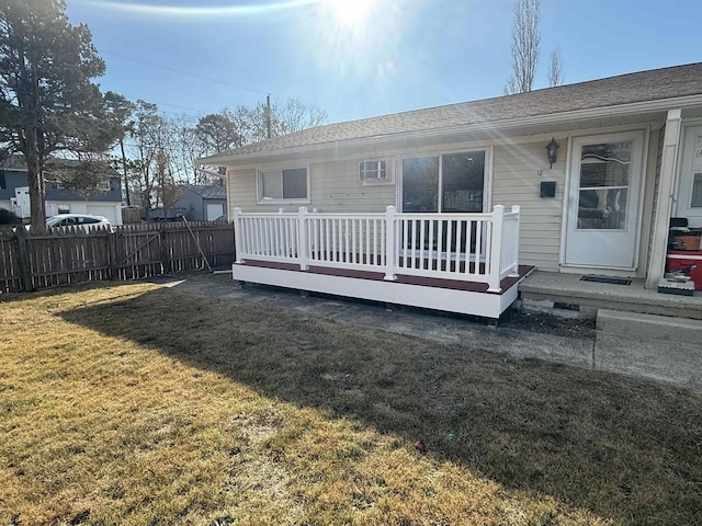 rear view of house with a wooden deck and a yard