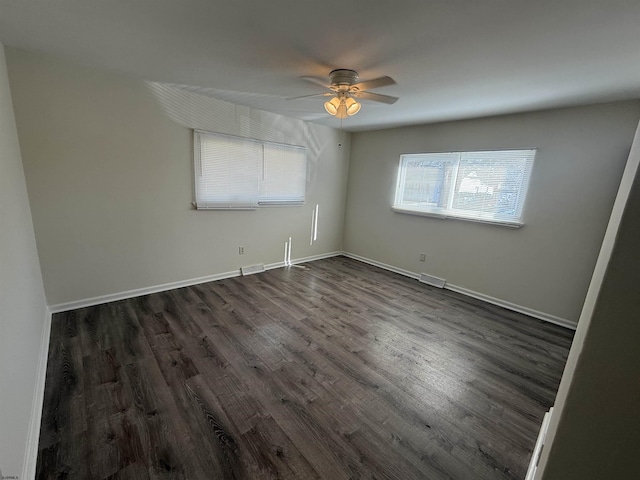 empty room with ceiling fan and dark hardwood / wood-style floors