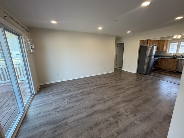 unfurnished living room with dark wood-type flooring and sink