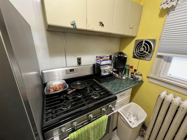 kitchen featuring radiator heating unit and stainless steel range with gas cooktop