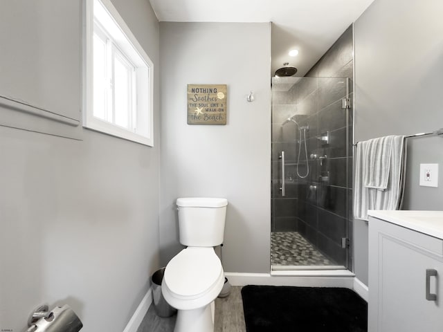 bathroom featuring walk in shower, vanity, toilet, and wood-type flooring