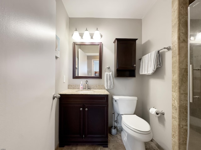 bathroom with vanity, a tile shower, and toilet