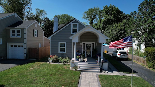 view of front facade with a garage, covered porch, and a front lawn