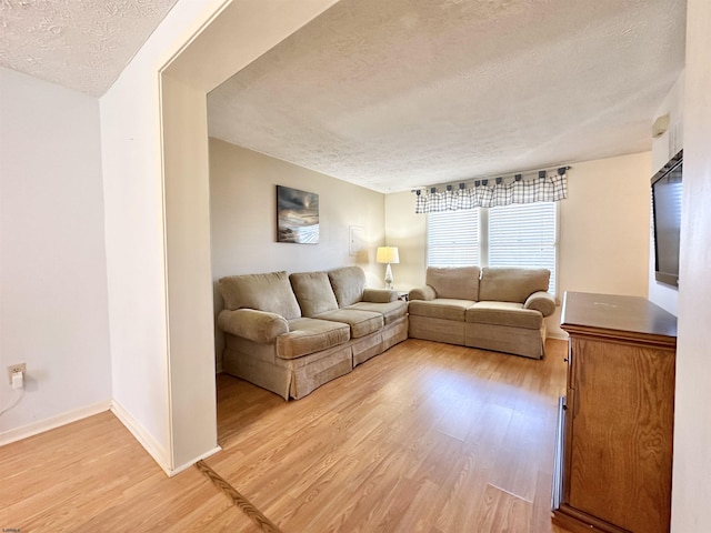 living room featuring light hardwood / wood-style flooring and a textured ceiling