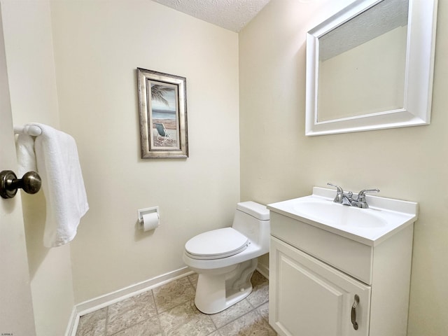 bathroom featuring vanity, a textured ceiling, and toilet