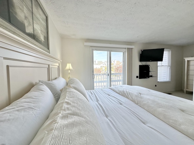 bedroom featuring access to outside and a textured ceiling