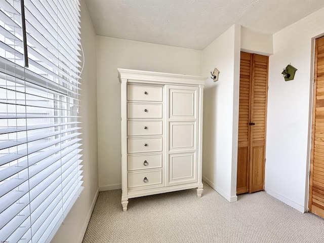 unfurnished bedroom with light colored carpet and a textured ceiling