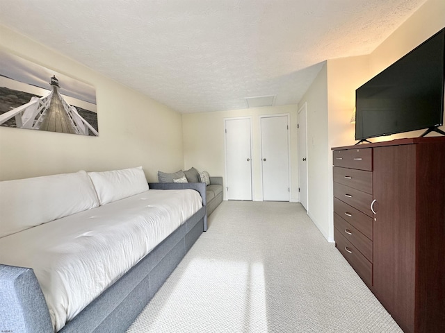 bedroom with light carpet and a textured ceiling