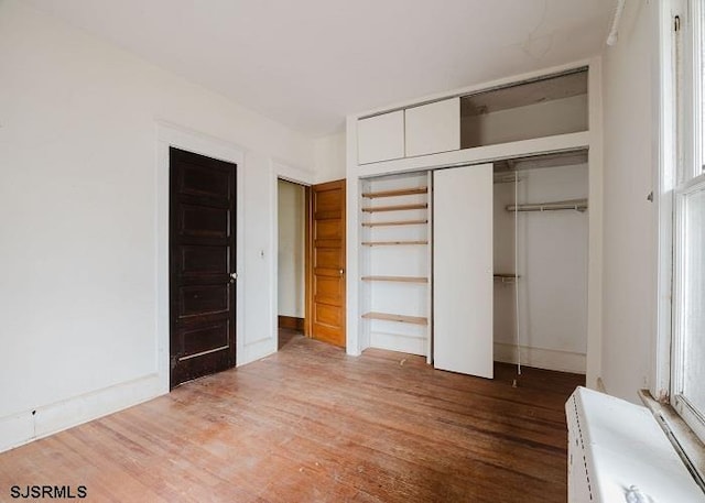 unfurnished bedroom featuring hardwood / wood-style flooring and a closet