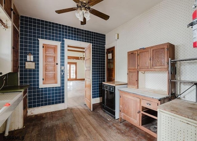 kitchen featuring ceiling fan, dark hardwood / wood-style flooring, and tile walls