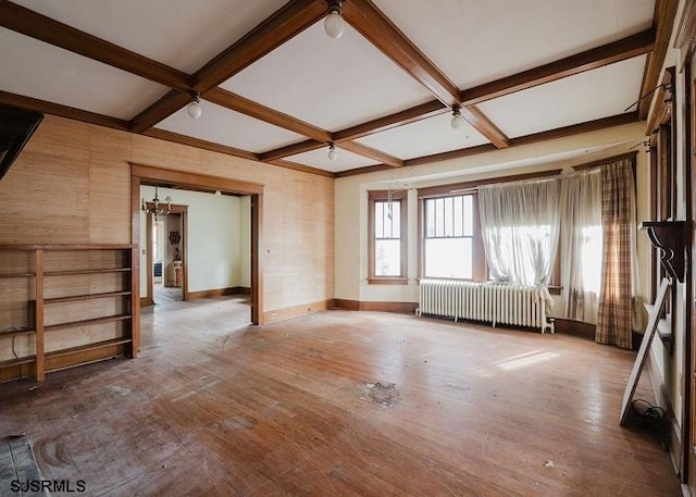 unfurnished living room with coffered ceiling, radiator, and hardwood / wood-style floors