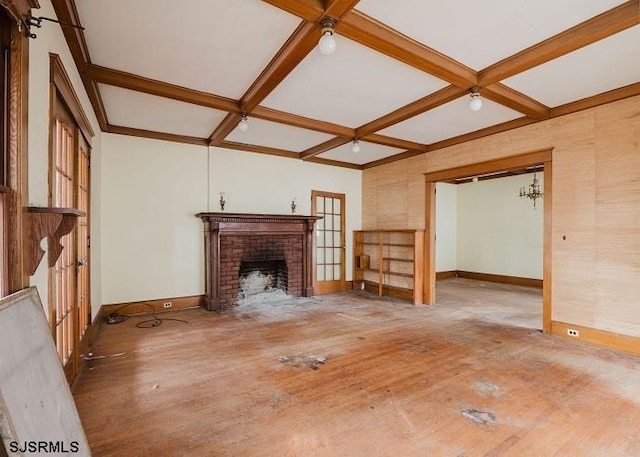 unfurnished living room with coffered ceiling, hardwood / wood-style flooring, and a fireplace