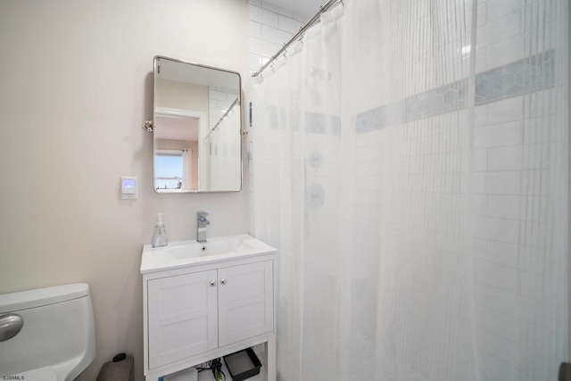 bathroom with vanity, a shower with shower curtain, and toilet