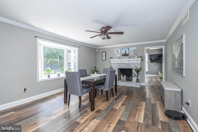 dining area with crown molding, a fireplace, dark hardwood / wood-style floors, and ceiling fan