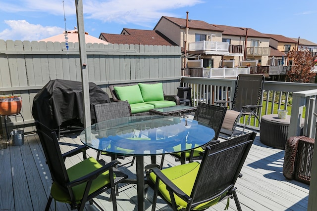 wooden terrace with an outdoor living space and grilling area