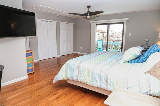 bedroom featuring hardwood / wood-style floors, two closets, access to outside, and ceiling fan