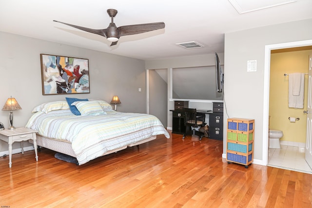 bedroom featuring ceiling fan, ensuite bath, and hardwood / wood-style floors