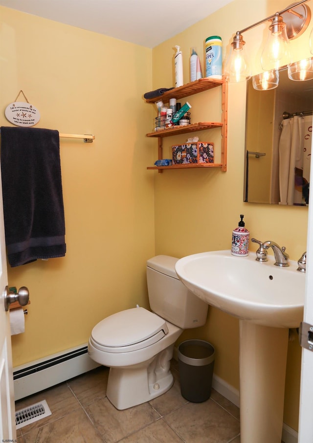 bathroom with toilet, tile patterned flooring, sink, and a baseboard heating unit