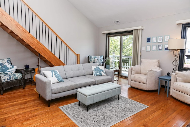 living room featuring wood-type flooring and high vaulted ceiling