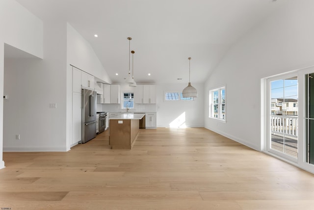 kitchen featuring light hardwood / wood-style flooring, hanging light fixtures, high quality appliances, white cabinets, and a kitchen island