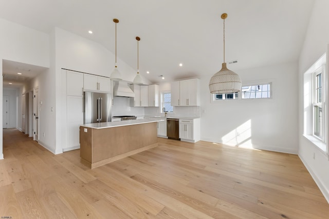 kitchen featuring hanging light fixtures, stainless steel appliances, a center island, and white cabinets