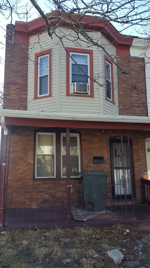 rear view of house featuring cooling unit and a porch